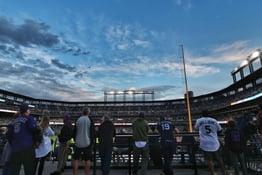 Fans watching a baseball game inside a stadium