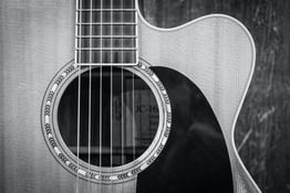 Black-and-white closeup photo of the cutaway of a guitar.