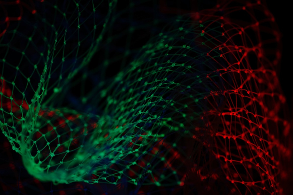 A wavy net pattern bathed in green and red light.