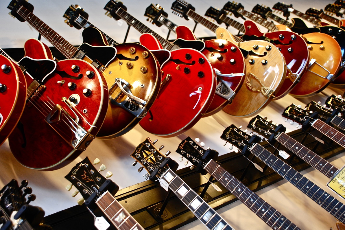 A selection of electric guitars hang from wall-mounted racks.